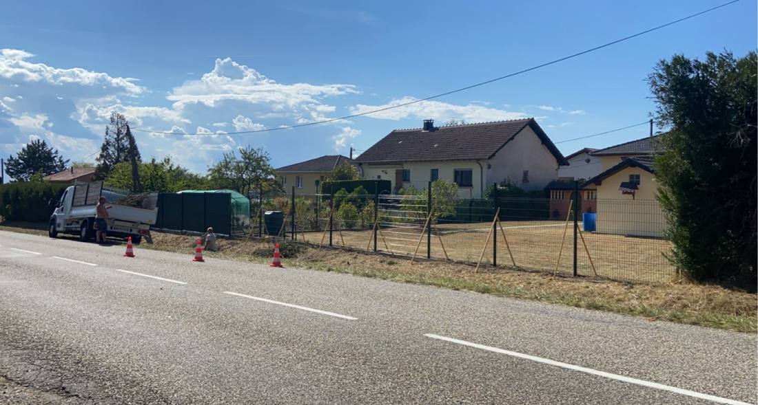 Pose d’une clôture rigide le long d’une route, poteaux étayés