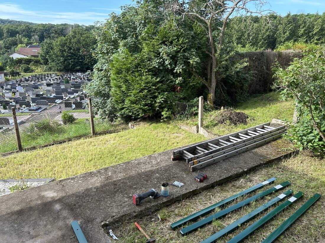Poteaux et outillage prêts avant la pose d’une clôture rigide